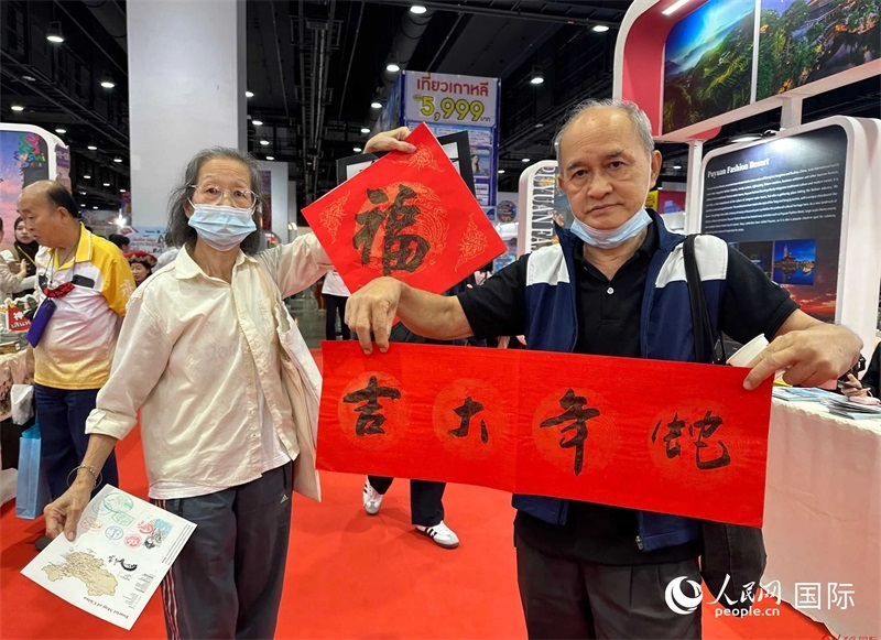 2025蛇年春節(jié)，泰國(guó)市民展示他們領(lǐng)到的華人手寫春聯(lián)。人民網(wǎng)記者 簡(jiǎn)承淵攝