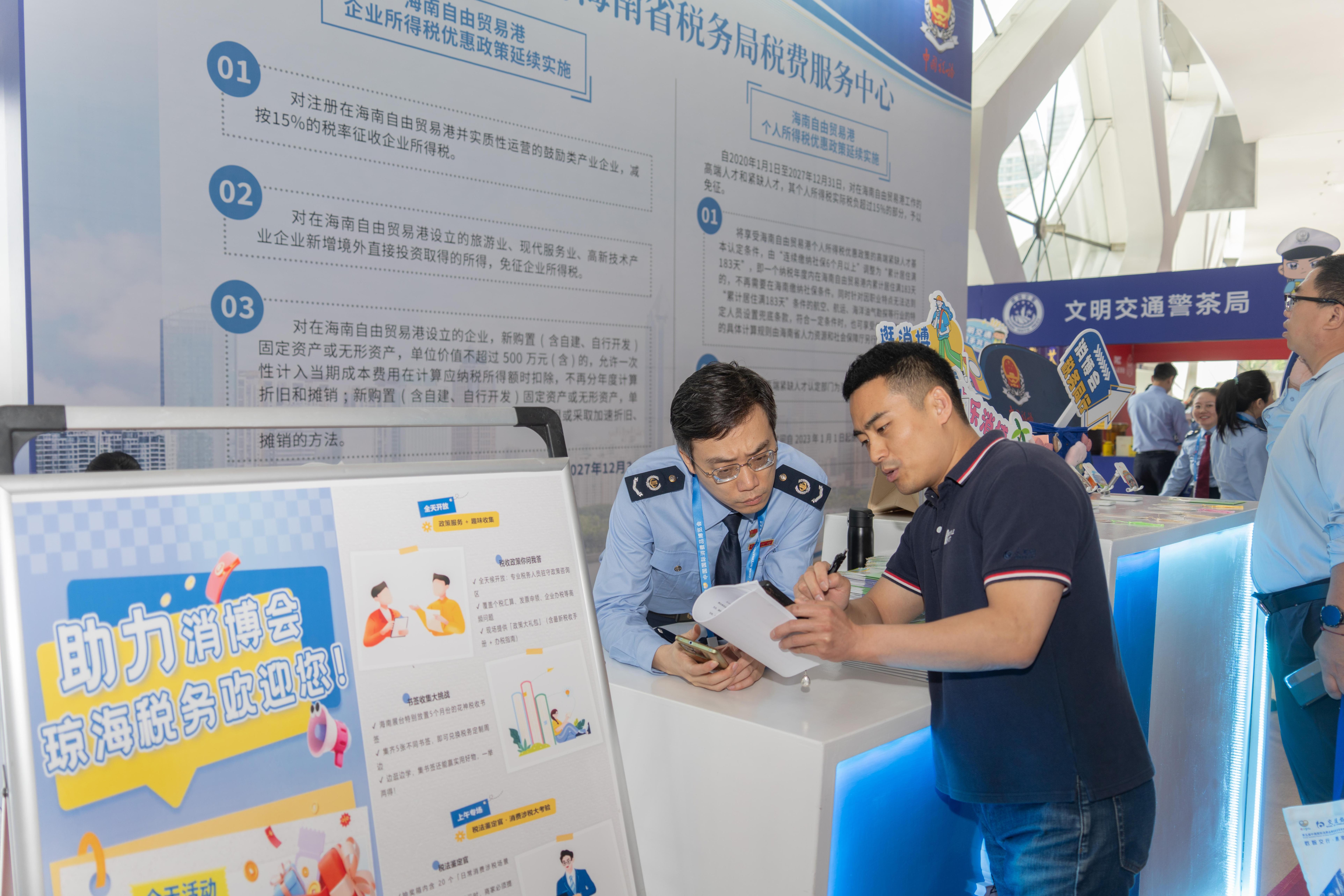 稅務(wù)服務(wù)臺(tái)工作人員向記者介紹服務(wù)參展外商的具體舉措。人民網(wǎng)記者 許崢攝