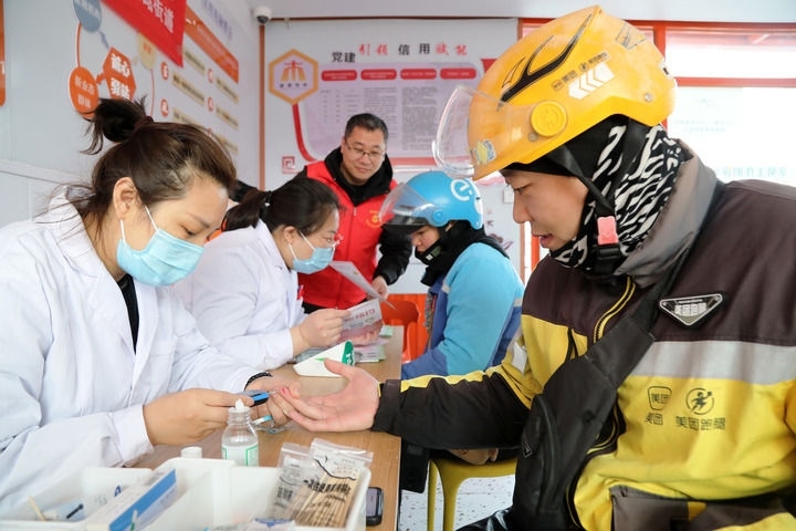 2025年3月5日，志愿者在山東省棗莊市市中區(qū)一工會驛站為外賣員免費測量血糖。新華社發(fā)（王海楠攝）