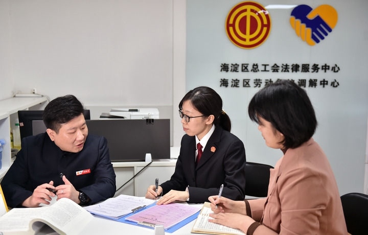 2025年3月6日，在北京市海淀區(qū)總工會勞動爭議調解中心，海淀區(qū)人民法院法官王琰（中）與該中心工作人員就糾紛化解情況進行溝通。新華社記者 趙婷婷 攝