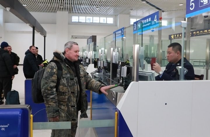 2024年12月10日，在黑河公路口岸旅檢大廳，黑河出入境邊防檢查站民警為首班次客車入境旅客辦理邊檢通關(guān)手續(xù)。當(dāng)日，中國黑河公路口岸—俄羅斯卡尼庫爾干公路口岸旅客運(yùn)輸正式開通。新華社發(fā)（劉松攝）