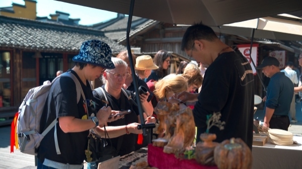 “五一”期間，游客正在烏鎮(zhèn)“水鄉(xiāng)碼頭”挑選購買文創(chuàng)產(chǎn)品。受訪者供圖