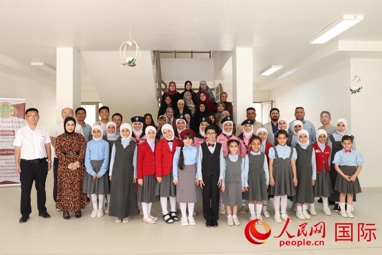 中國電建員工與阿爾穆塔?阿里卡特國際學校的師生及政府官員等合影。人民網(wǎng)記者 薛丹攝