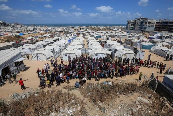 5月28日，人們在加沙城西部的沙提難民營等待領(lǐng)取救助食物。新華社發(fā)（里澤克·阿卜杜勒賈瓦德攝）