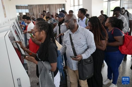 5月31日，在蒙內(nèi)鐵路內(nèi)羅畢站，乘客在自助取票機(jī)前排隊(duì)取票。新華社記者 楊光 攝