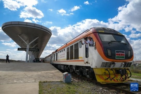 5月31日，在蒙內(nèi)鐵路內(nèi)羅畢站，機(jī)車駕駛員蔣立平（右）和博爾在即將開往蒙巴薩的E2次列車上揮手致意。新華社記者 楊光 攝