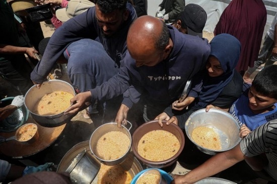 5月28日，人們在加沙城西部的沙提難民營領(lǐng)取救助食物。新華社發(fā)（里澤克·阿卜杜勒賈瓦德攝）