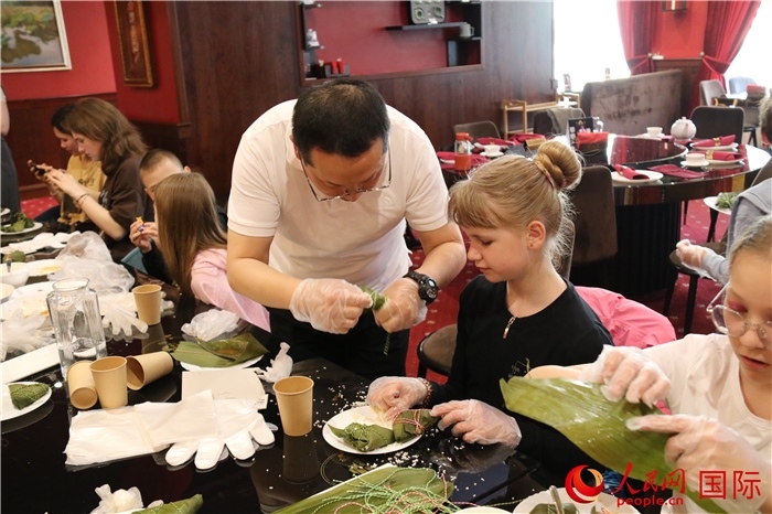 烏克蘭兒童學(xué)習(xí)體驗包粽子。人民網(wǎng)記者蔡子暢攝