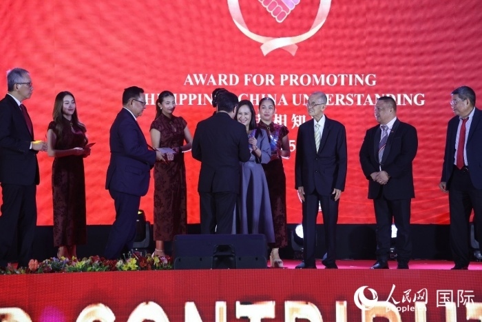 黃溪連大使給榮獲“重要貢獻獎”的奎松市市長喬伊·貝蒙蒂等人頒獎。人民網(wǎng)記者 樊帆攝